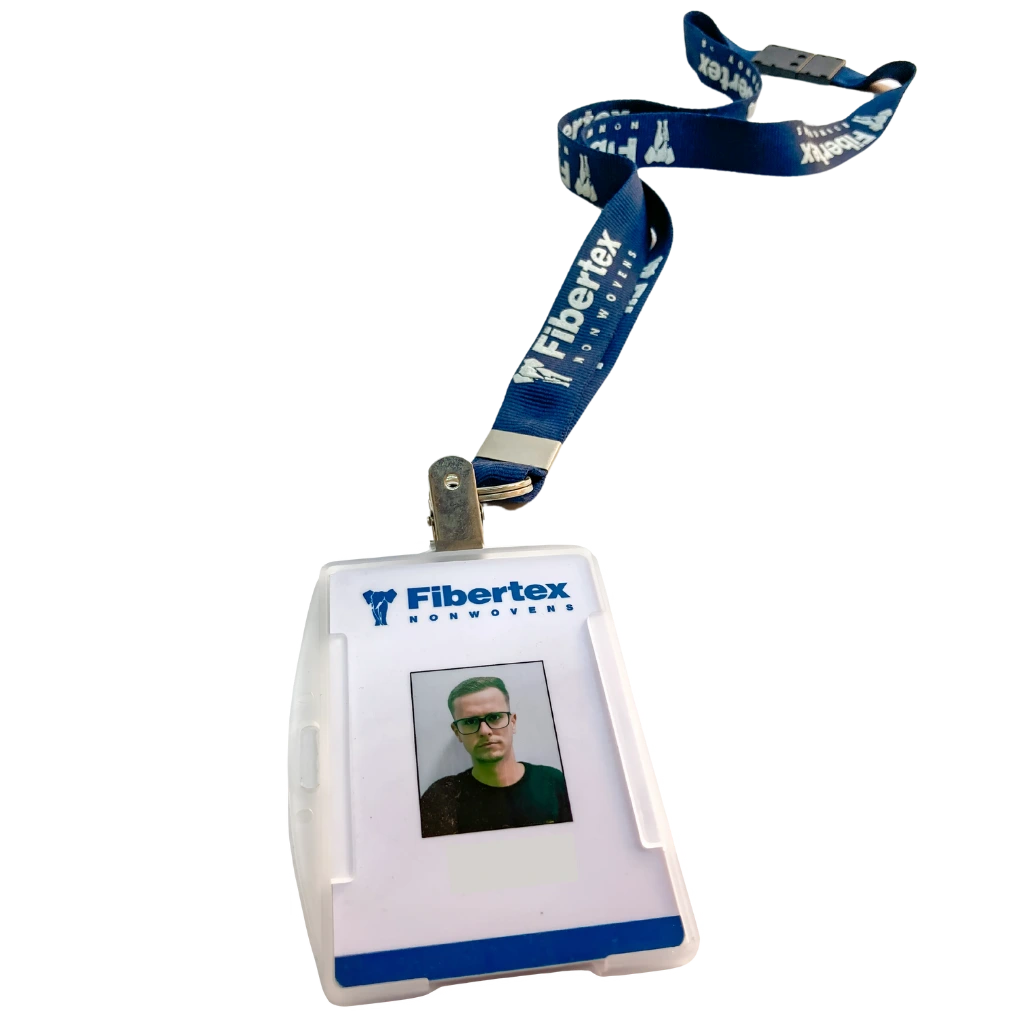 Crachá de identificação da empresa Fibertex Nonwovens com foto de um funcionário e cordão azul personalizado.