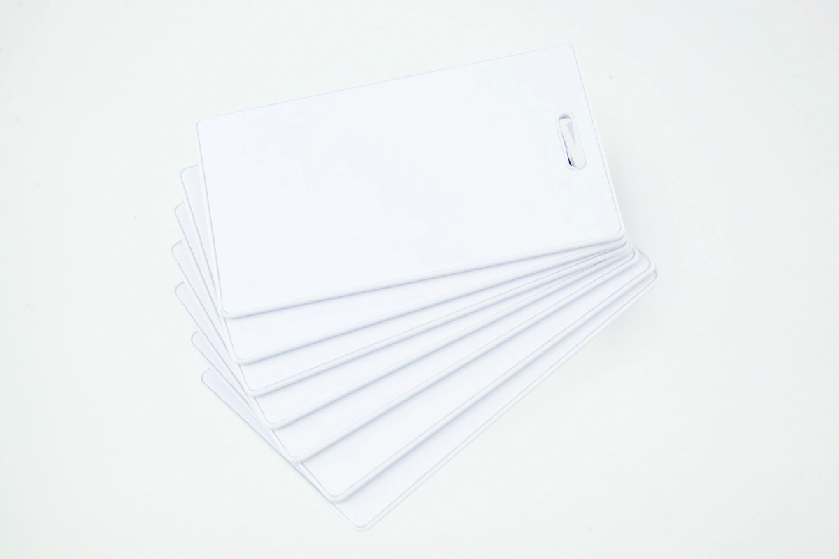 Cartões e crachás RFID/NFC em branco, prontos para personalização e uso em sistemas de controle de acesso.